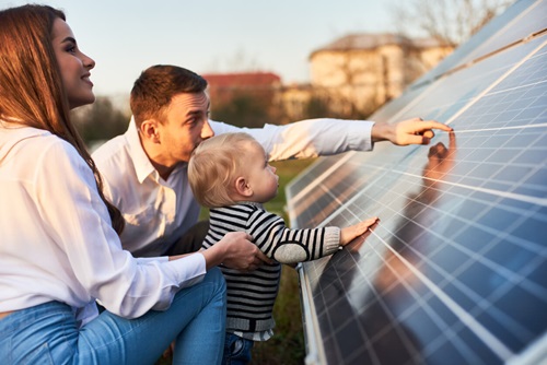 young family admires solar panel